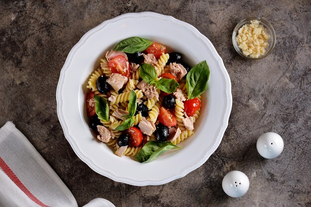 Ensalada de atún, pasta, tomates cherry, aceitunas, parmesano y albahaca