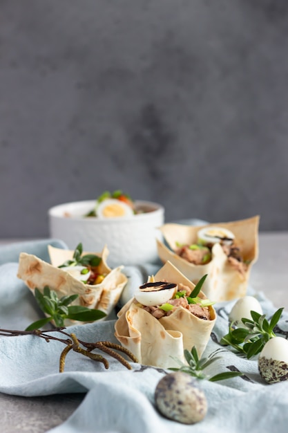 Ensalada de atún con pepino, pimiento, maíz y huevo de codorniz en tartaletas hechas de lavash