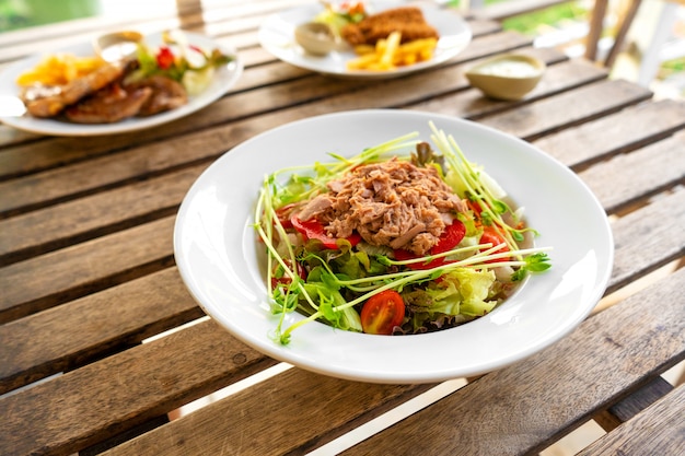 Ensalada de atún en un plato sobre una mesa en un café de verano