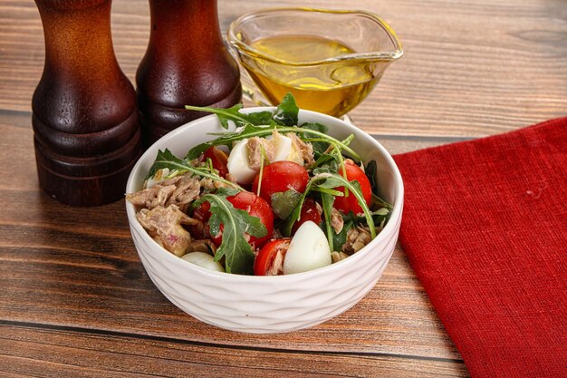 Foto ensalada con atún, tomate, huevo de codorniz y rúcula