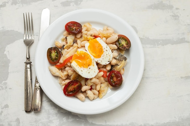 Ensalada con bacalao frito y alubias blancas en el plato