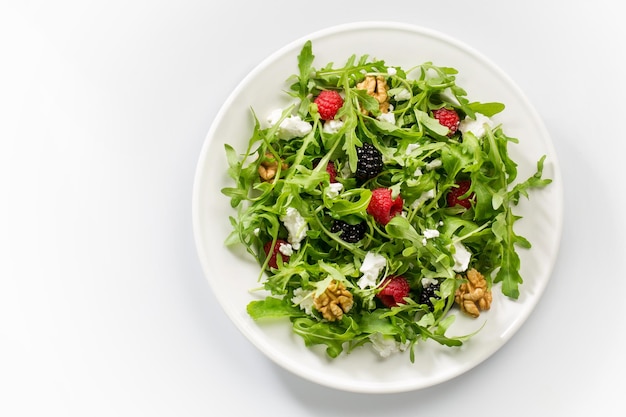 Ensalada de bayas con verduras, almendras, nueces, queso de cabra y rúcula