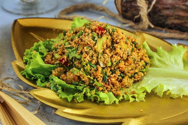 Ensalada de bulgur con verduras en un plato dorado