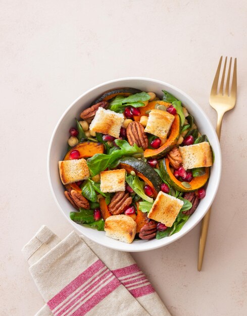 Ensalada con calabaza, granada, pecanas y picatostes. Alimentación saludable. Comida vegetariana.