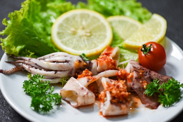 Ensalada de calamar con salsa de chile, hierbas y especias picantes / Rebanada de calamar a la plancha en un plato en el restaurante de mariscos