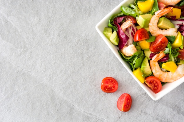 Ensalada de camarones con mango y aguacate en piedra gris vista superior copia espacio