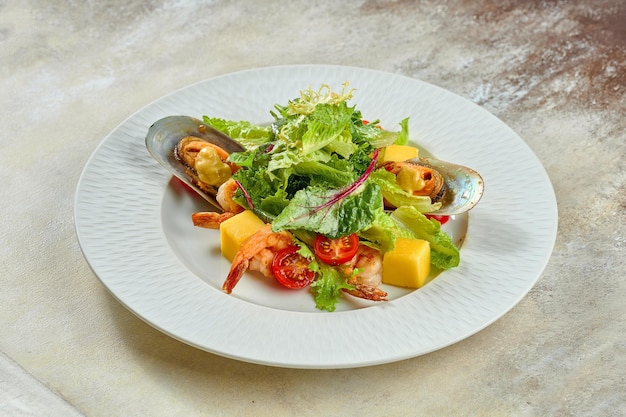 Ensalada de camarones y mejillones, mango en un plato blanco sobre un mantel