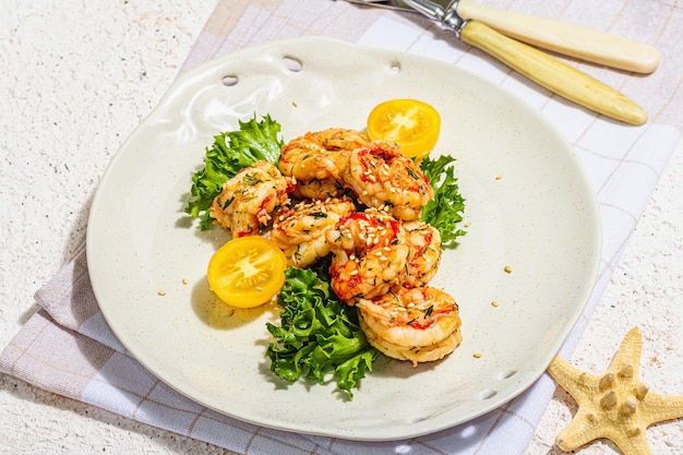 Ensalada de camarones a la parrilla con lechuga, tomate, cerezas y especias en un plato Mariscos frescos y saludables