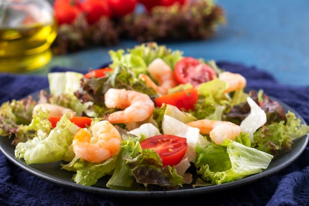 Foto ensalada de camarones, tomates y verduras mixtas en un plato. comida sana. comida dietetica. de cerca