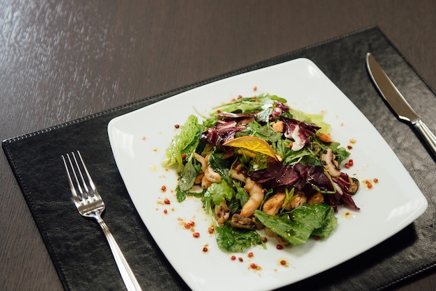 Ensalada con camarones y verduras en un plato sobre la mesa