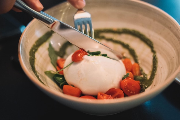 Ensalada caprese con burrata mozarella tomates cherry y salsa pesto