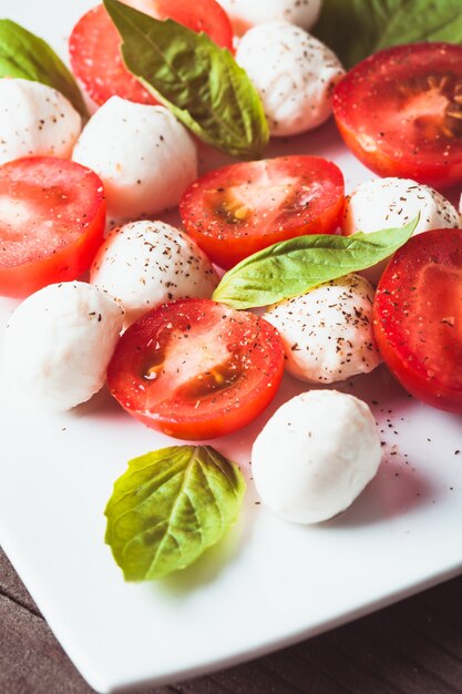 Ensalada caprese clásica: tomate, mozzarella y hojas de albahaca