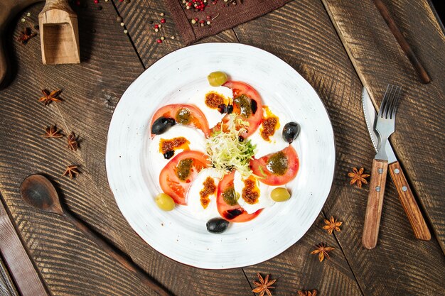 Ensalada Caprese gourmet en una placa blanca.