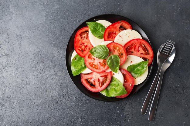 Foto ensalada caprese hecha de tomates frescos en rodajas queso mozzarella y albahaca