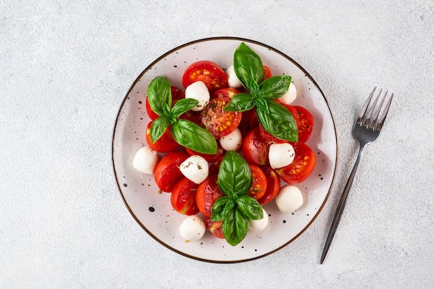 Ensalada caprese italiana con rodajas de tomate mozzarella albahaca aceite de oliva sobre un fondo oscuro Vista superior Comida italiana Ensalada saludable Comida de verano