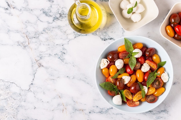 Ensalada caprese italiana con tomates, queso mozzarella, albahaca, aceite de oliva, vista superior.