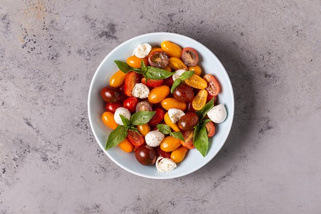 Ensalada caprese italiana con tomates, queso mozzarella, albahaca, aceite de oliva, vista superior.