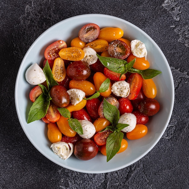 Ensalada caprese italiana con tomates, queso mozzarella, albahaca, aceite de oliva, vista superior.