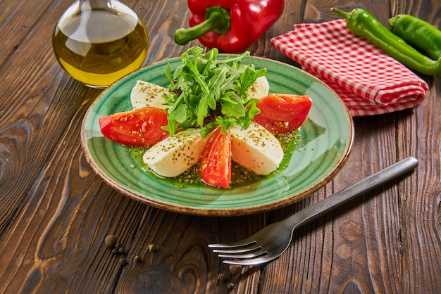 Ensalada caprese italiana con tomates y queso mozzarella en mesa de madera