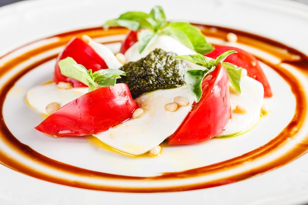 Ensalada caprese con mozzarella tomate albahaca y pesto