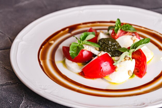 Ensalada caprese con mozzarella tomate albahaca y pesto