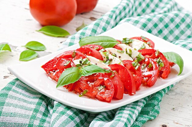 Ensalada caprese. Rodajas de tomate y mozzarella con hojas de albahaca.