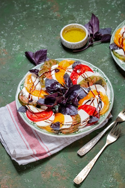 Ensalada Caprese Rodajas de tomate y mozzarella con hojas de albahaca