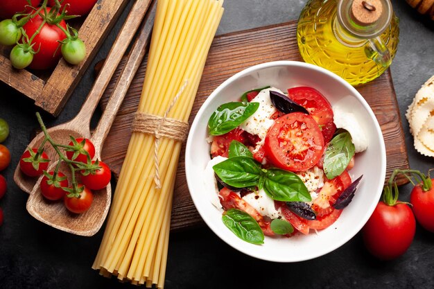 Ensalada caprese con tomates frescos, albahaca de la huerta y queso mozzarella