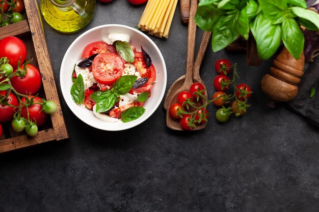 Ensalada caprese con tomates frescos, albahaca de la huerta y queso mozzarella