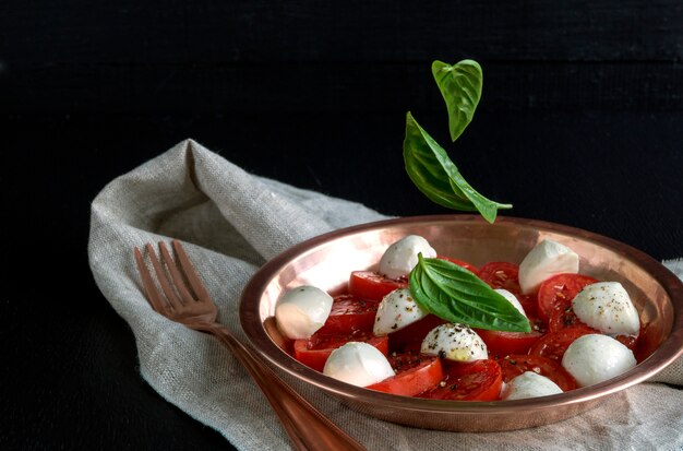 Ensalada Caprese Con Tomates Maduros Y Mozzarella Con Hojas Frescas De Albahaca. Comida italiana.