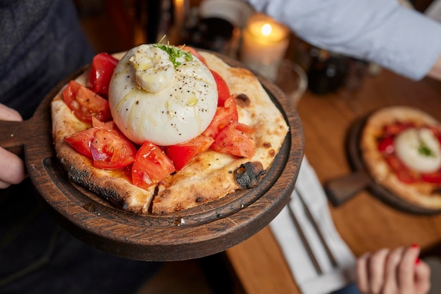 Ensalada Caprese con tomates, queso mozzarella, albahaca, fondo oscuro, primer plano, vista superior