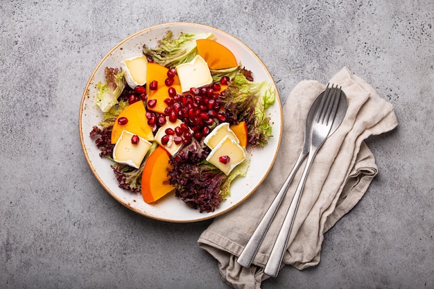 Ensalada de caqui vegetariana saludable con vista superior de brie