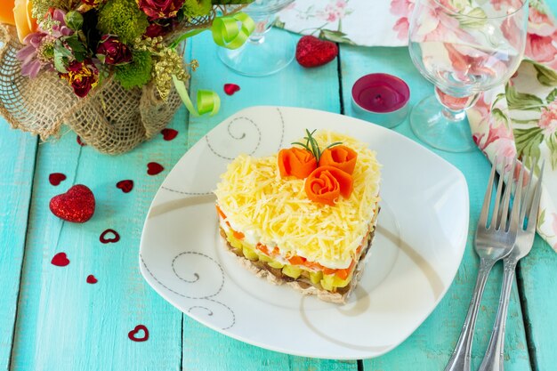 Ensalada de carne, champiñones, queso y verduras en la mesa festiva del día de San Valentín.