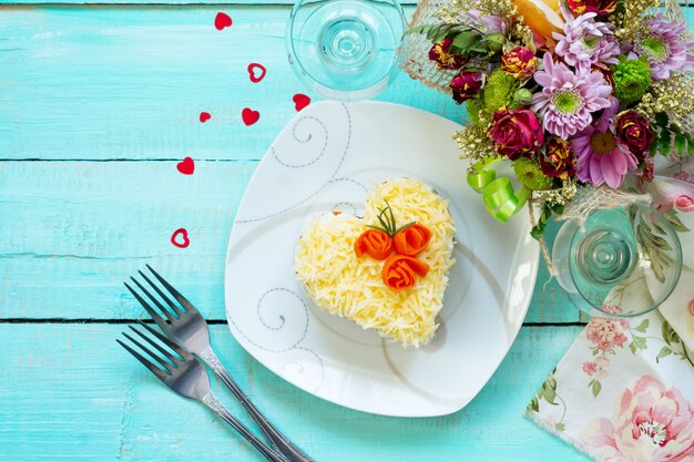 Ensalada de carne, champiñones, queso y verduras en la mesa festiva del día de San Valentín.