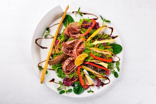 Ensalada con carne y hojas de ensalada Sobre una superficie de madera Vista superior Espacio libre para el texto