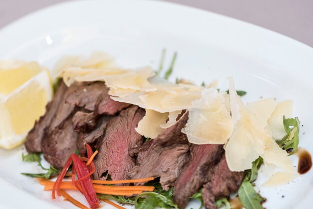 Ensalada de carne a la parrilla, acompañada de parmesano y rúcula.