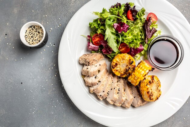 Ensalada de carne de pollo y verduras frescas de maíz a la parrilla y salsa. Concepto de deliciosa comida equilibrada, banner, menú, lugar de receta para texto, vista superior.