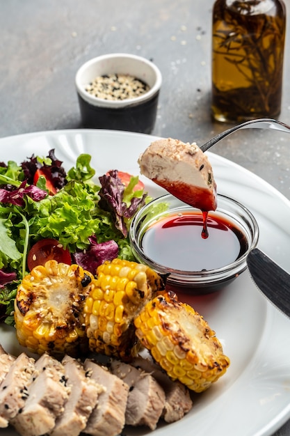 Ensalada de carne de pollo y verduras frescas de maíz a la parrilla y salsa. Concepto de deliciosa comida equilibrada, banner, menú, lugar de receta para texto, vista superior.