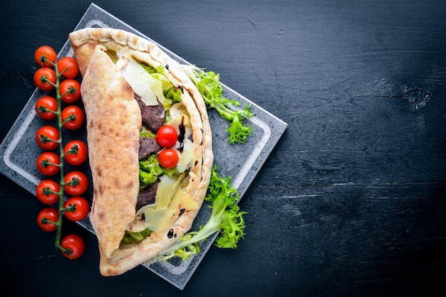 Ensalada de carne con verduras frescas en masa horneada Sobre un fondo de madera Vista superior Espacio libre para el texto