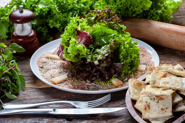 Ensalada de carpaccio con lechuga y queso parmesano rallado