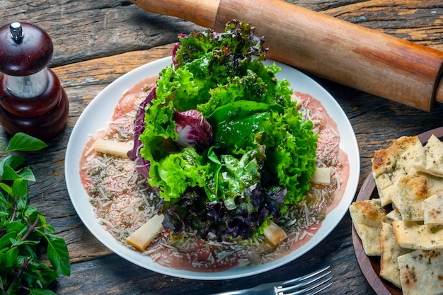 Ensalada de carpaccio con lechuga y queso parmesano rallado