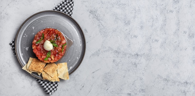 Foto ensalada casera de carpaccio de tomate con mozzarella, aceite de oliva y albahaca con pan árabe