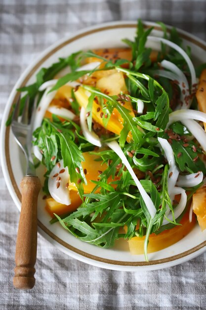 Ensalada casera saludable con rúcula y tomate amarillo en un plato