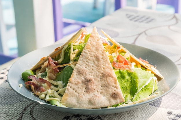 ensalada de ceasar con pan de pizza en el plato