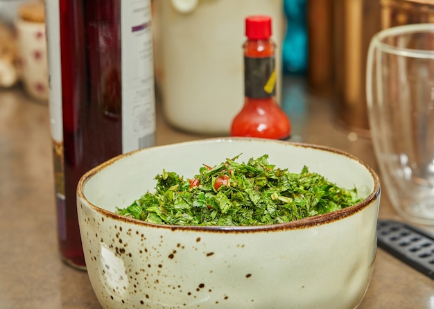Ensalada con cebollas verdes, tomates y albahaca mezclados en un tazón hondo.