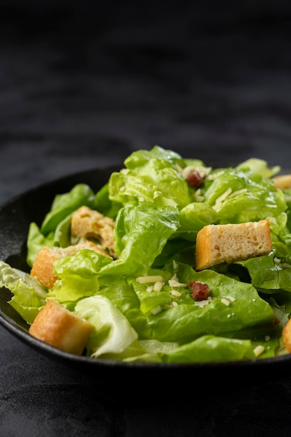 Ensalada César con picatostes y tocino.