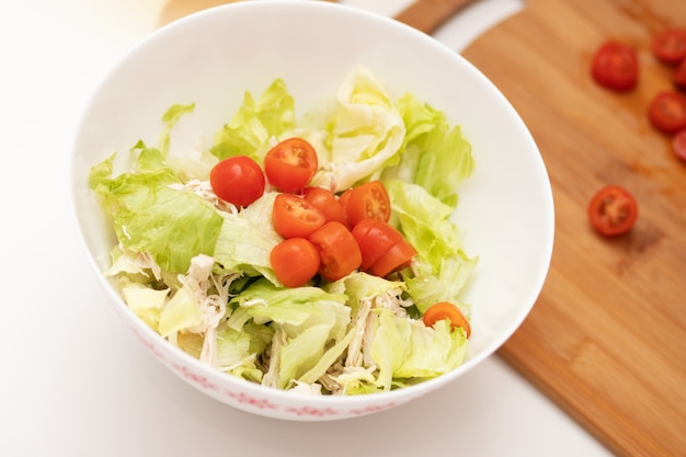 Ensalada César con pollo y hojas de iceberg y tomates pequeños.