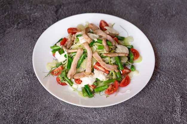 Ensalada César con pollo y parmesano, tomate cherry, lechuga, picatostes y huevo,