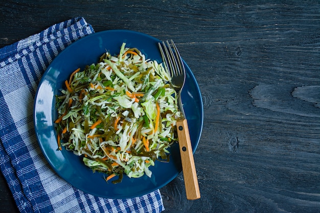 Ensalada de col blanca, col rizada y zanahorias frescas sazonadas con aceite de oliva