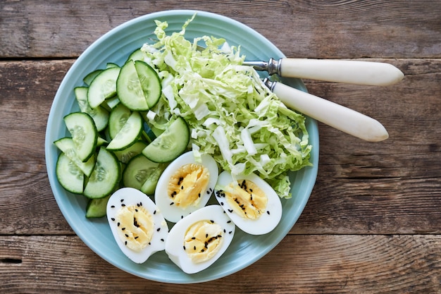 Ensalada con col china, pepinos y huevos cocidos en un plato